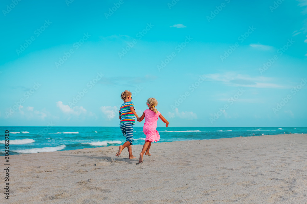 happy girl and boy run on beach, kids enjoy vacation at sea