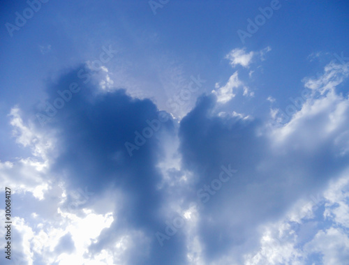 Clouds like a heart and rays of the sun breaking through them. Symbol of love in the sky.