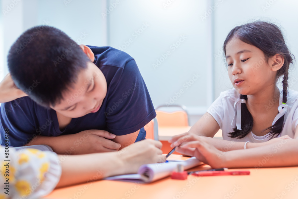 Asian elementary school girl and boy are studying and having fun in the classroom with female teachers. Asian elementary school girl and boy are studying and having fun in the classroom with female teachers.