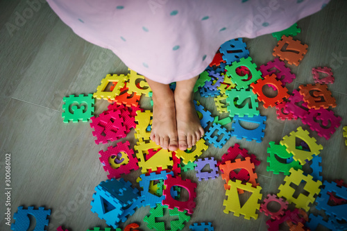 too much toy , little girl steps on puzzle trying to go through