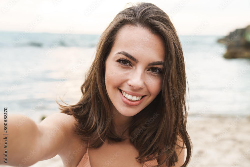 Image of joyful caucasian woman smiling and taking selfie photo Image of joyful caucasian woman smiling and taking selfie photo