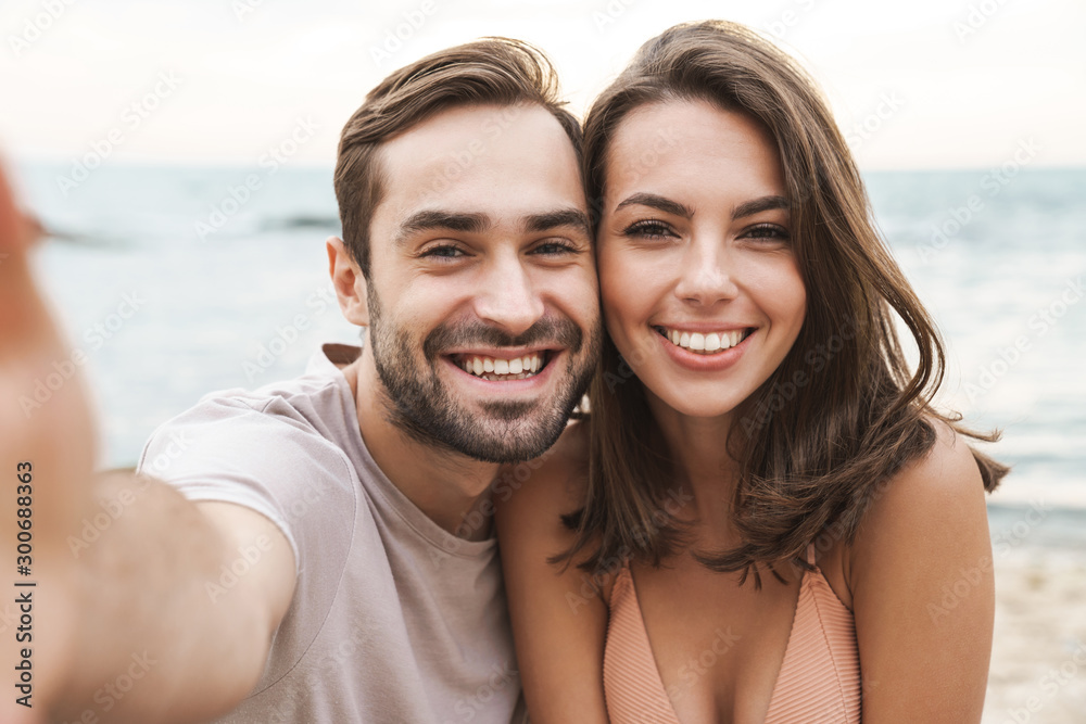 Photo of joyful young couple smiling and taking selfie photo Photo of joyful young couple smiling and taking selfie photo