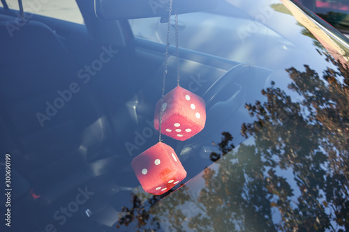 Fuzzy dice hanging on the rearview mirror in a car for good luck. photo