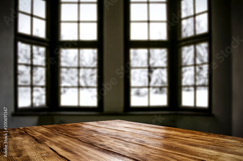 Table top with big window background and beautiful snowy winter landscape outside. Sunny winter day.