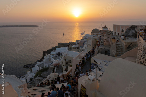 Crowds of people watching the Santorinian sunset from the city of Oia.