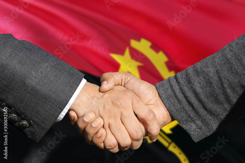 Angola handshake concept on national flag background. Partnership and business agreements, shaking hands.