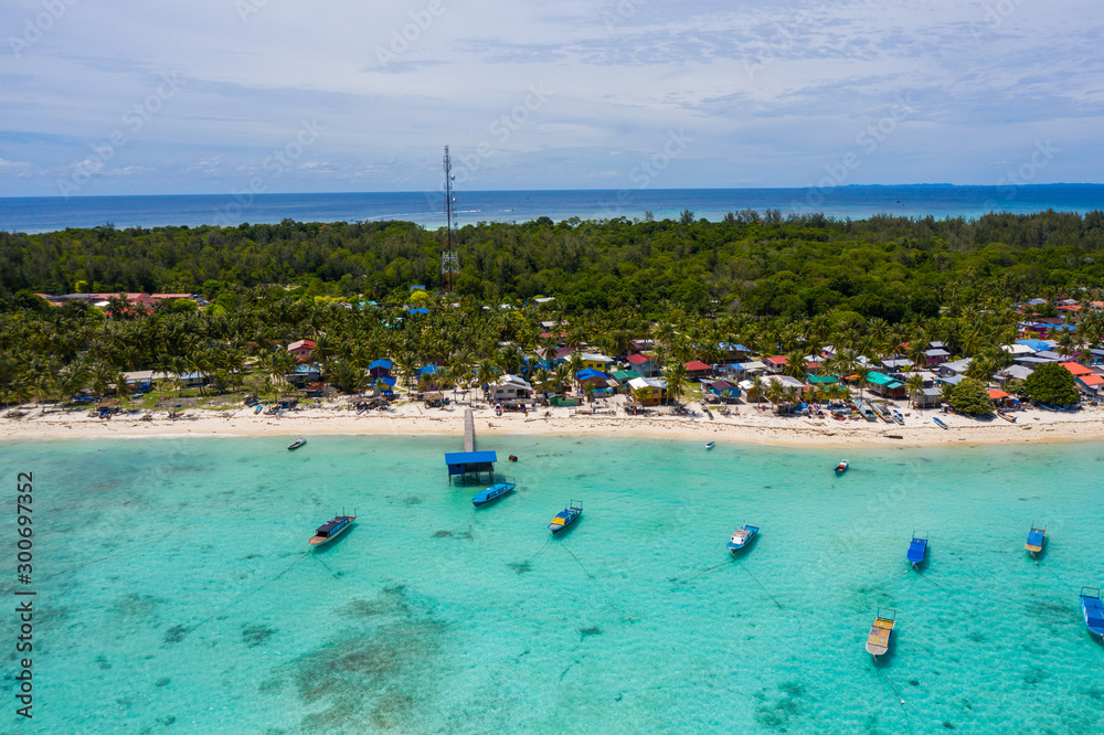 Obraz premium Aerial drone image of beautiful white sandy beach tropical island with turquoise sea water and Malay traditional fisherman village at Mantanani Island, Sabah, Borneo - Travel Concept