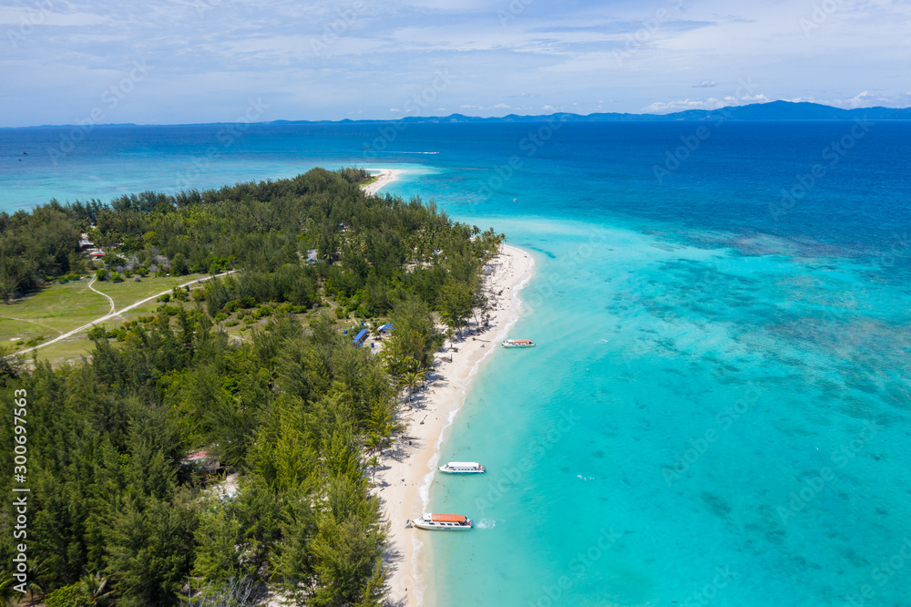 Beautiful white sandy beach tropical island with turquoise sea water and Malay traditional fisherman village at Mantanani Island, Sabah, Borneo