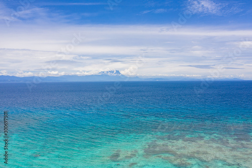Aerial Drone view of beautiful Mount Kinabalu view from Mantanani Island, Sabah, Malaysia during clear blue sky and crystal clear sea water 