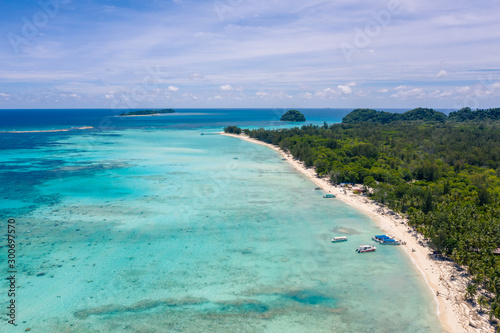 Beautiful white sandy beach tropical island with turquoise sea water and Malay traditional fisherman village at Mantanani Island  Sabah  Borneo