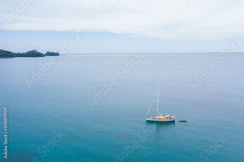 Aerial view of white Yacht in deep blue sea with beautiful landscape view in Kudat, Sabah, Borneo