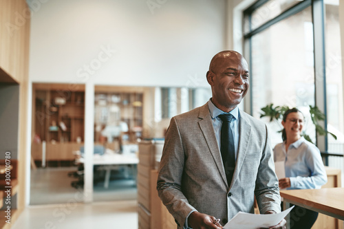 African American businessman laughing while walking through a mo