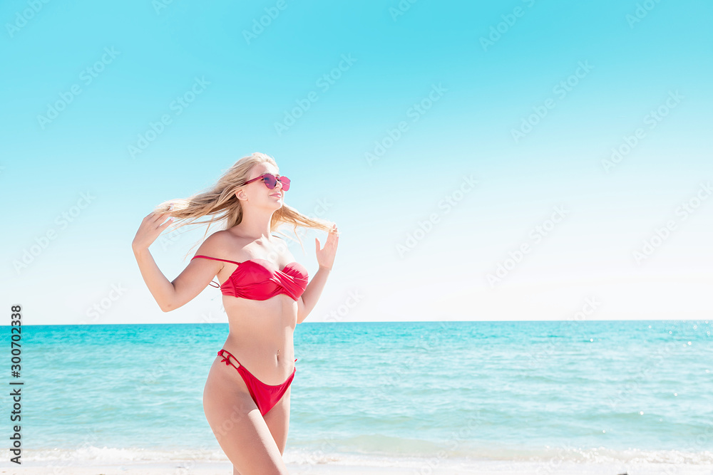 Portrait of a blonde in pink glasses at the sea. A woman walks along the beach and enjoys. Portrait of a blonde in pink glasses at the sea. A woman walks along the beach and enjoys.
