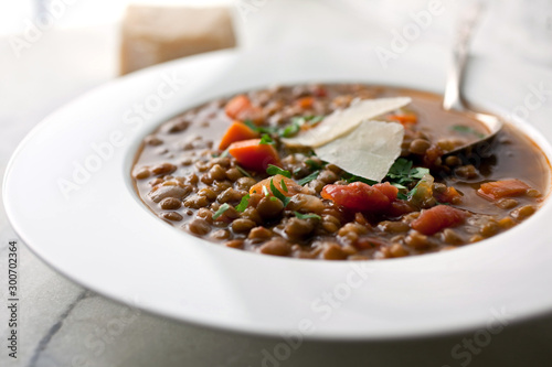 Close up of lentil and tomato soup served on soup plate