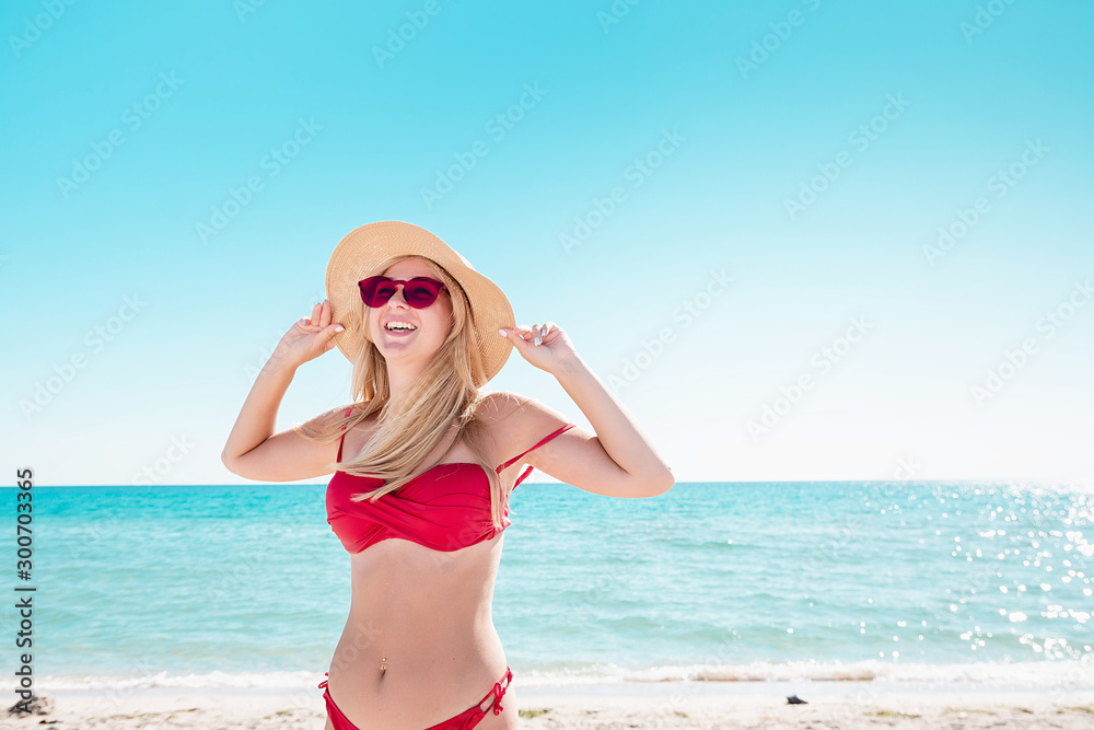 Portrait of a blonde in pink glasses at the sea. A woman walks along the beach and enjoys. Portrait of a blonde in pink glasses at the sea. A woman walks along the beach and enjoys.