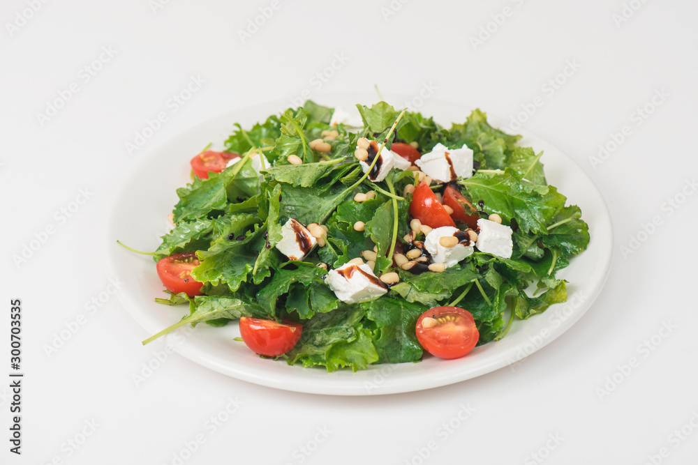 Green salad with vegetables: greens, arugula, tomato, cheese pine nuts and sauce Green salad with vegetables: greens, arugula, tomato, cheese pine nuts and sauce
