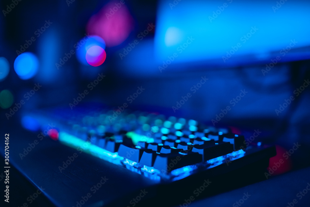 Blurred background computer, keyboard, blue and red lights. Concept eSports arena for gamer playing tournaments
