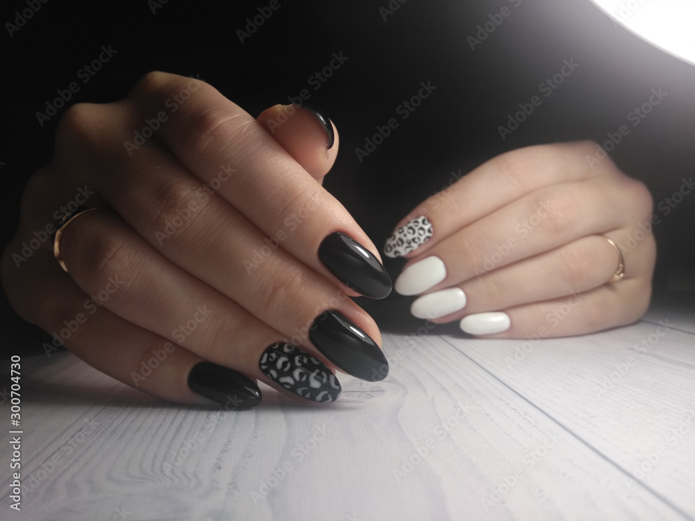 Black manicure with white leopard spots. White gel polish with a black leopard print design on a long round nails. Stock Photo | Adobe Stock Black manicure with white leopard spots. White gel polish with a black leopard print design on a long round nails. Stock Photo | Adobe Stock