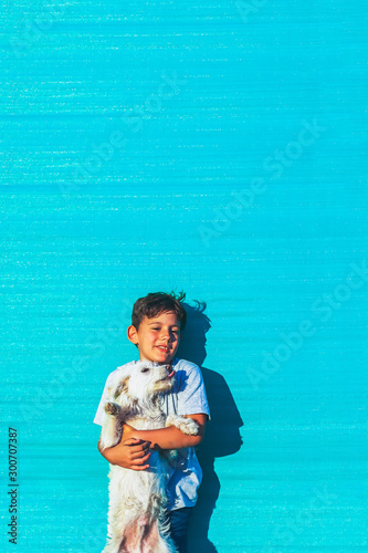 Happy cute young man holding his dog on a summer day