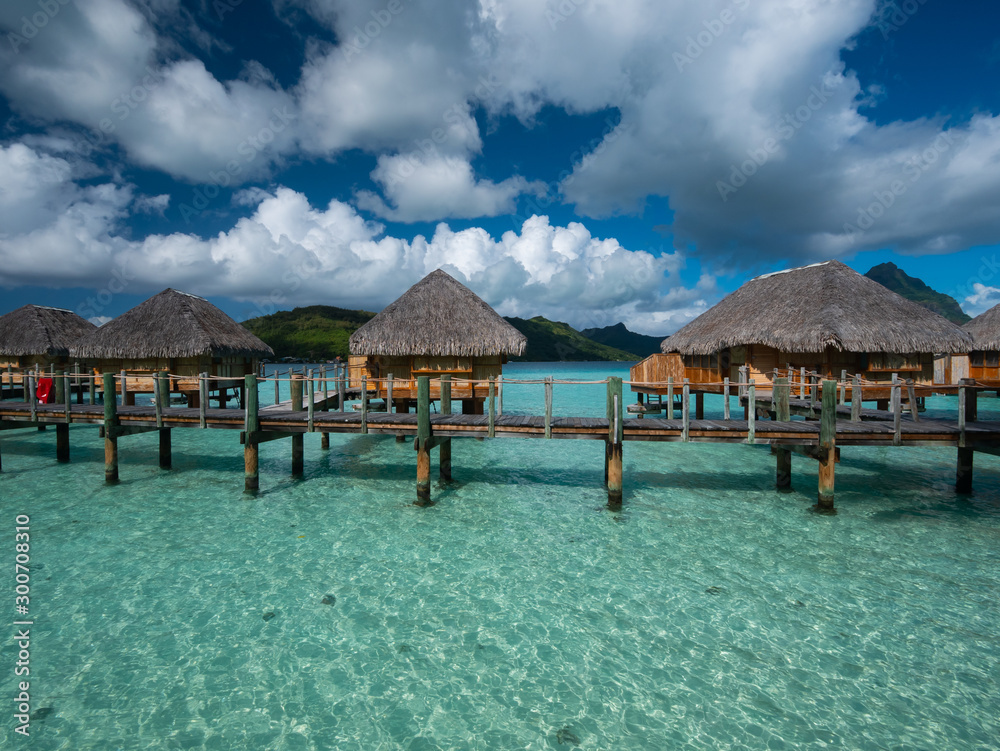 Luxury overwater villas on blue lagoon, white sandy beach and Otemanu mountain at Bora Bora island, Tahiti, French Polynesia. Luxury overwater villas on blue lagoon, white sandy beach and Otemanu mountain at Bora Bora island, Tahiti, French Polynesia.