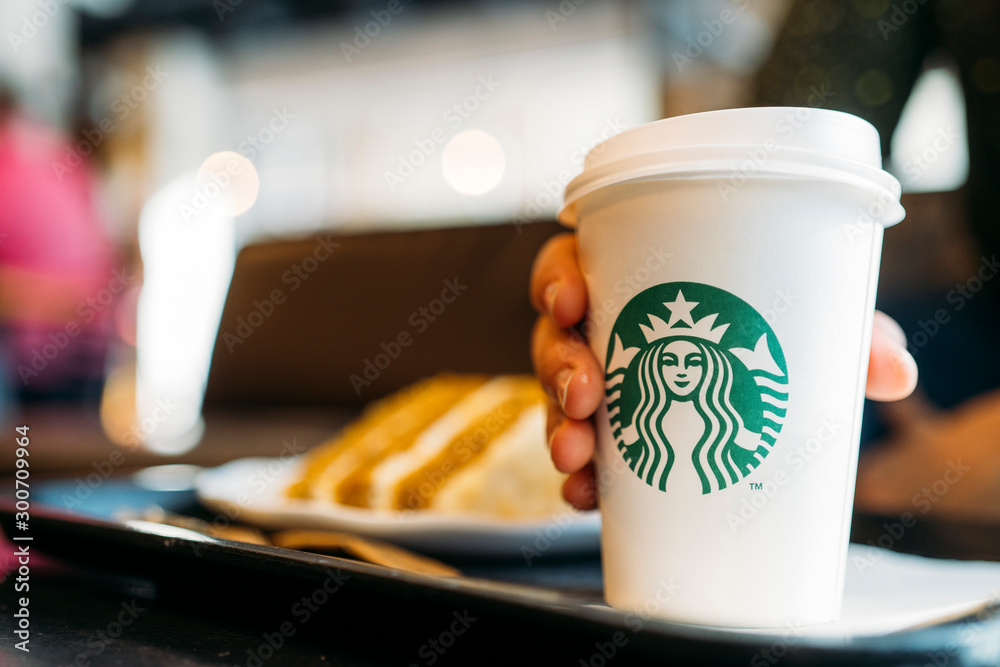 Fotka „New York, USA - November 5, 2019 : A tall Starbucks coffee in  starbucks coffee shop with cake. Starbucks is the world's largest coffee  house with over 20,000 stores in 61