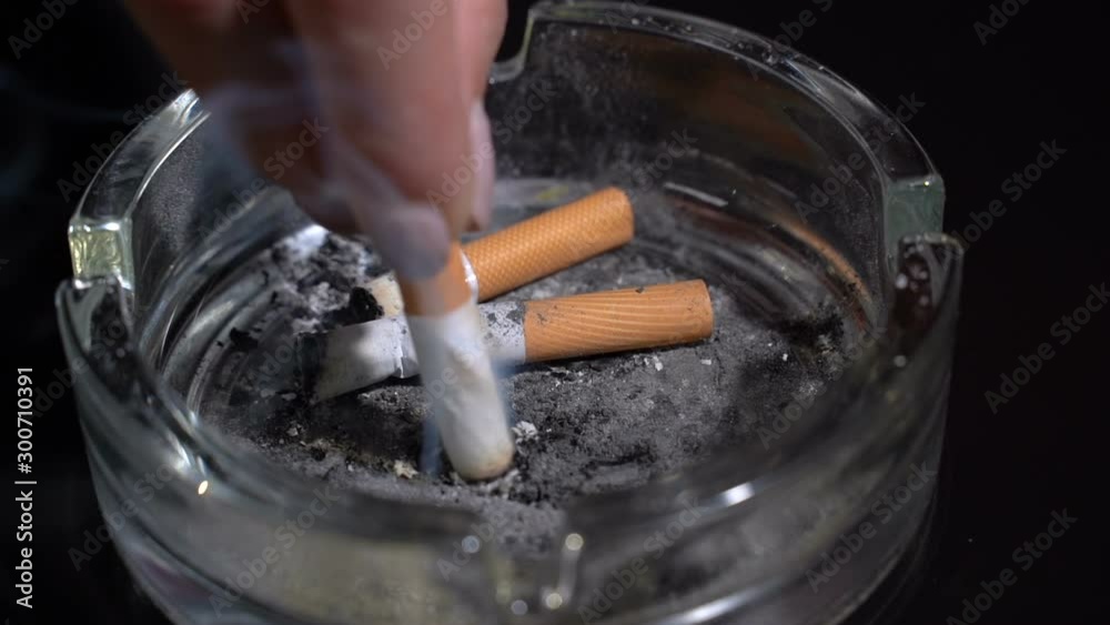 Hand extinguish a cigarette in an ashtray close-up.Slow motion