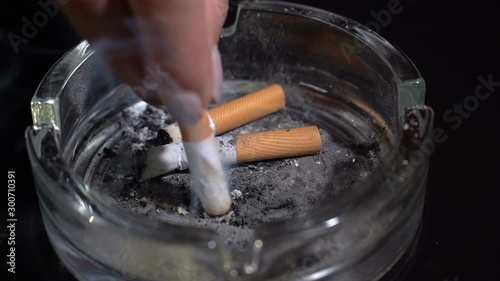 Hand extinguish a cigarette in an ashtray close-up.Slow motion
