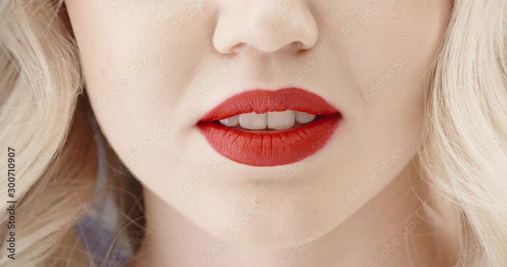 Close up shot of girl wearing makeup with red lipstick and perfect teeth doing a seductive growl - emotions concept 4k footage Close up shot of girl wearing makeup with red lipstick and perfect teeth doing a seductive growl - emotions concept 4k footage