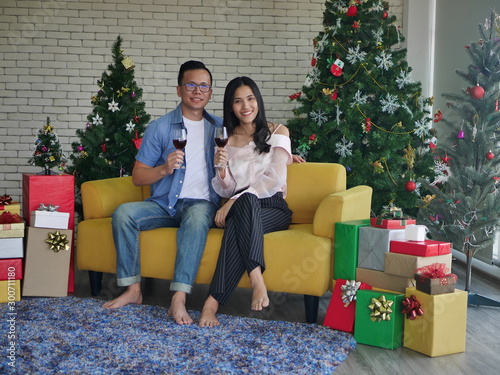 happy couple with gifts in front of christmas tree