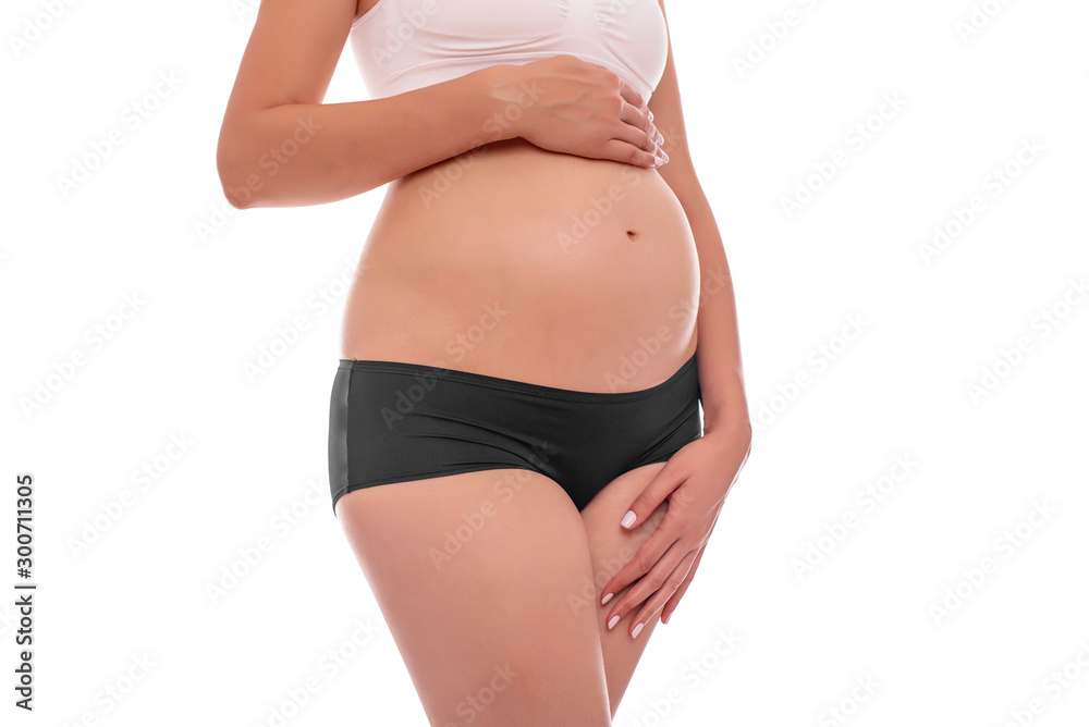 The body of a pregnant young woman on a white background. The body of a pregnant young woman on a white background.