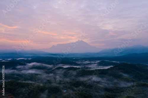 Aerial drone image of Beautiful harmony romantic color sunrise landscape scenery with sunlight and fog and Mount Kinabalu as background in Guakon, Sabah, Malaysia