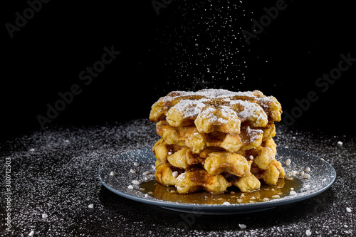 Fresh crispy Belgian waffles tower with icing sugar and  crunchy sugar crystals