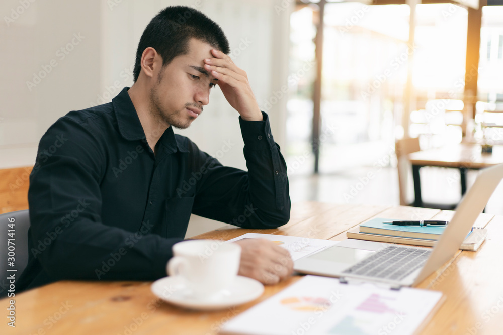 The man are stressed at work in the office. Asian businessman stressful and headache with laptop computer. Young male with headache at office, feeling sick at work. The man are stressed at work in the office. Asian businessman stressful and headache with laptop computer. Young male with headache at office, feeling sick at work.