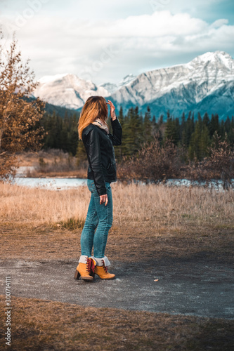 Girl in leather jacket standing infrot of mountains © Braeden