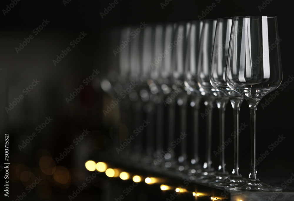 Empty clean glasses on table against dark background. Space for text Empty clean glasses on table against dark background. Space for text