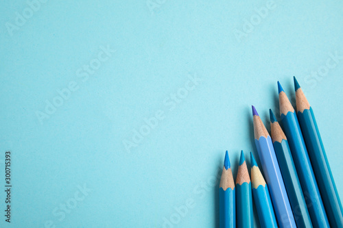 Flat lay composition with color pencils on light blue background. Space for text photo