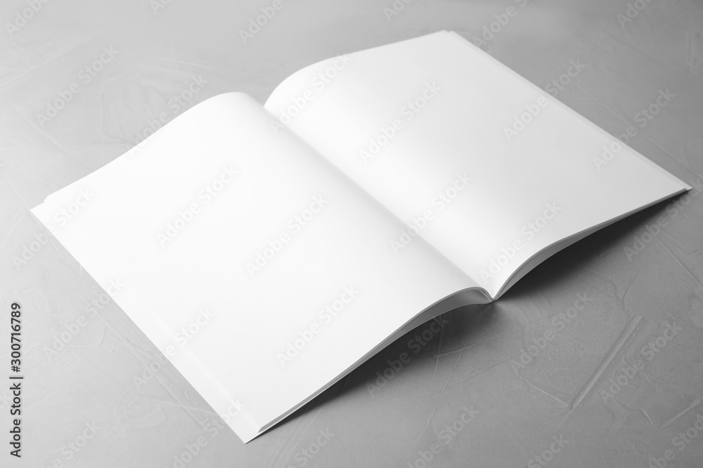 Blank open book on light grey stone background. Mock up for design - obrazy, fototapety, plakaty 