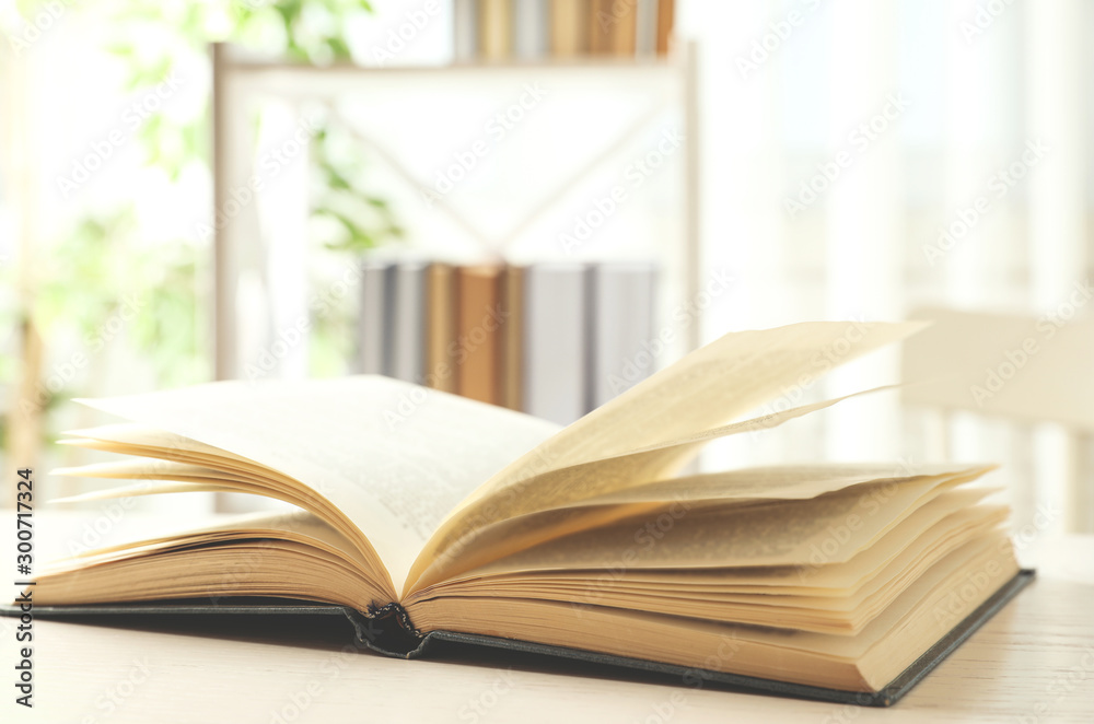 Open hardcover book on white wooden table indoors Open hardcover book on white wooden table indoors