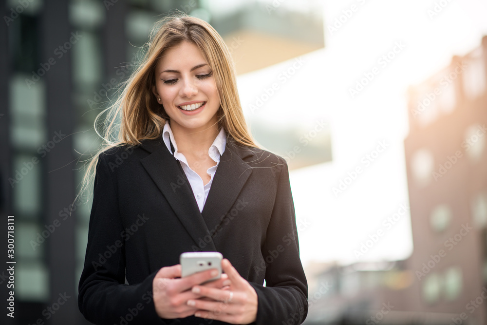 Smiling business woman using her mobile phone