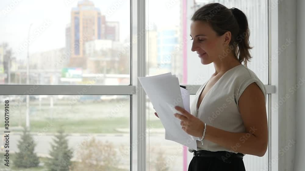 An office worker studies important documents and drinks coffee.