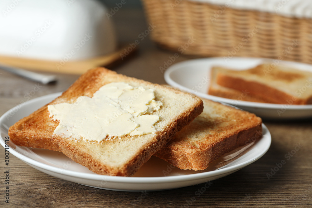 Crispy toasted bread with butter on wooden table, closeup Crispy toasted bread with butter on wooden table, closeup