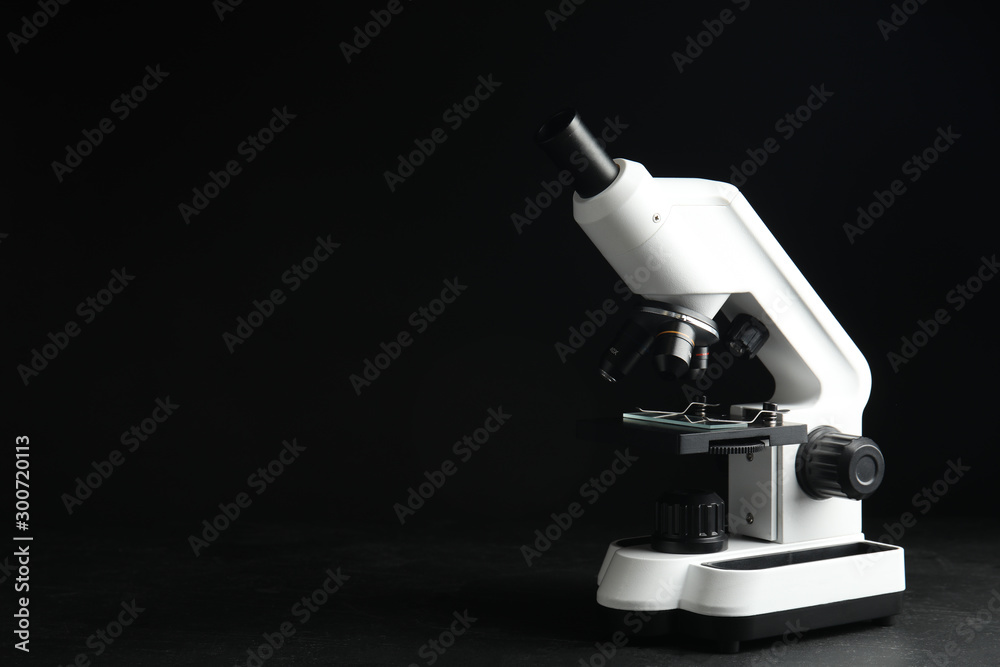 Modern microscope on black background, space for text. Medical equipment Modern microscope on black background, space for text. Medical equipment
