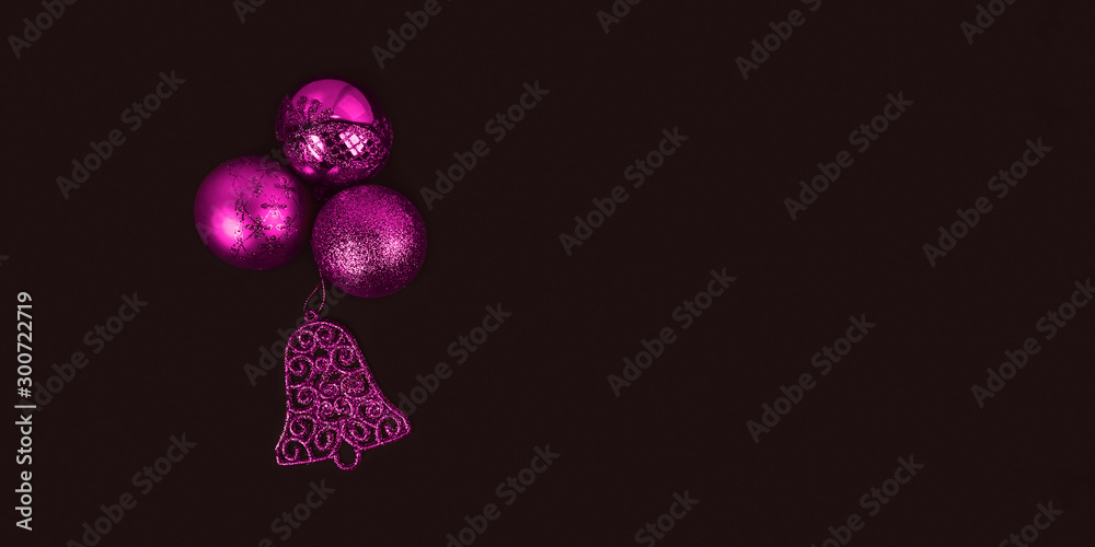 Pink New Year's toys on dark background. Christmas balls and bell. Merry Christmas and Happy New Year decoration concept Pink New Year's toys on dark background. Christmas balls and bell. Merry Christmas and Happy New Year decoration concept