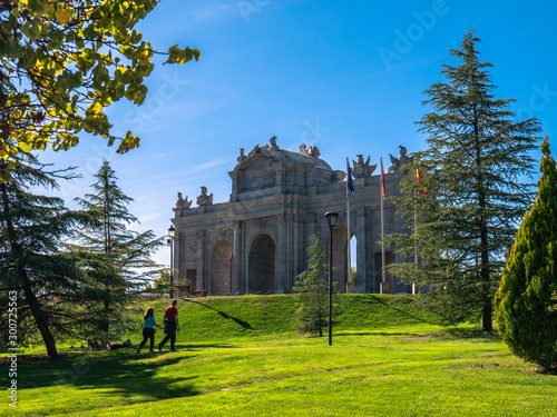 Replica of the Puerta de Alcala in Madrid, in the Europa park of Torrejon de Ardoz, surrounded by trees and a beautiful blue sky in the background