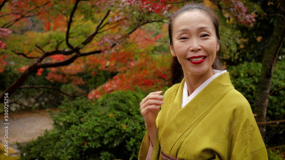 Elegant Japanese woman enjoying a walk in the forest with fall colors in Kyoto Japan Elegant Japanese woman enjoying a walk in the forest with fall colors in Kyoto Japan