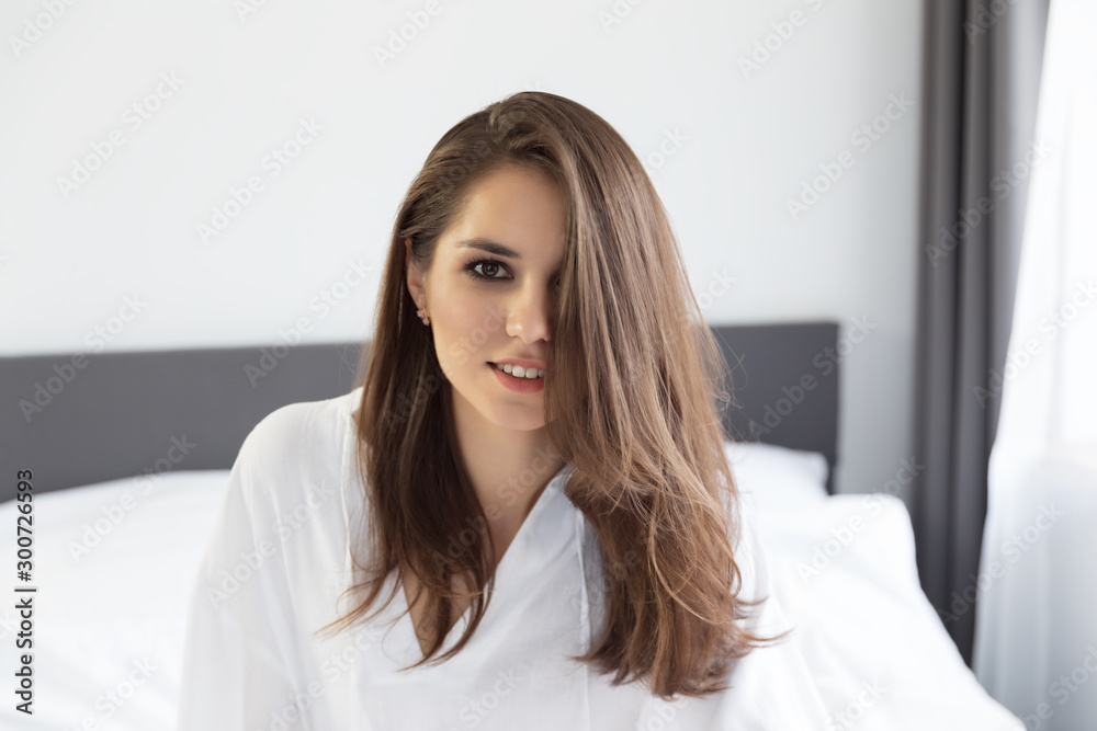 Woman enjoying morning awakening in a soft snow-white bed. Woman enjoying morning awakening in a soft snow-white bed.