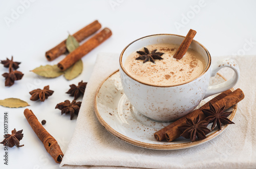 Indian Masala chai tea. Traditional Indian hot drink with milk and spices on white background closeup.
