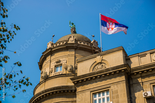 BEOGRAD, SERBIA: Flag of Serbia on the roof of the rear. Beautiful street with houses in the old town. photo