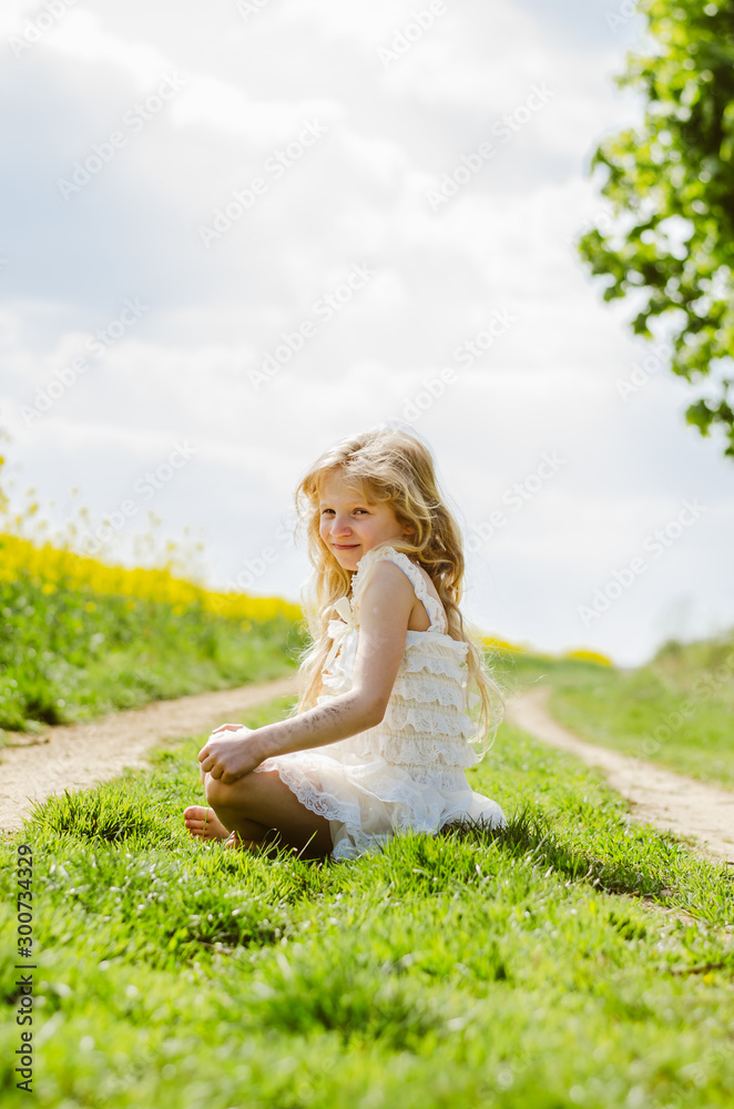 charming caucasian child sitting alone in spring nature charming caucasian child sitting alone in spring nature
