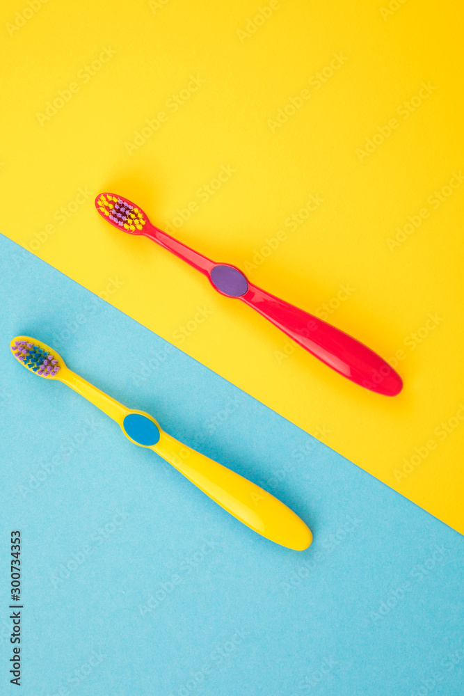Teeth brushing concept. Toothbrushes on a yellow and blue background top view Teeth brushing concept. Toothbrushes on a yellow and blue background top view